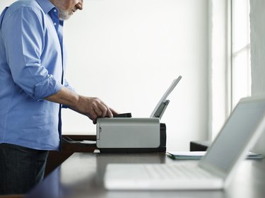 Man Using Printer At Study Table In House