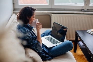 Cropped image of woman using laptop with blank screen