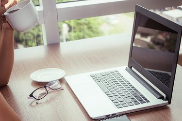 Cropped Image Of Businesswoman Drinking Coffee At Desk In Office