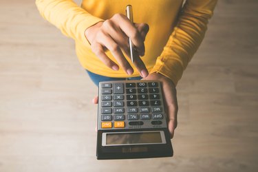 Woman using a calculator with a pen in her hand