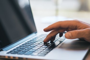 Closeup of man using laptop on desk top