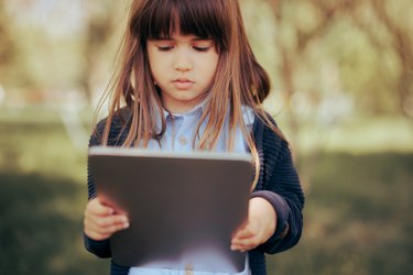 Little Girl Holding a Pc Tablet for electronic Learning.