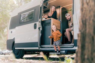 Family with their dogs enjoying life in campervan, father mother and son with their dogs camping, happy family enjoying a road trip with their dogs