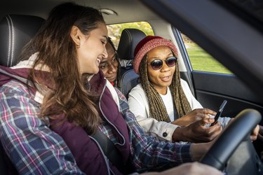 Friends using gps on their mobile phone during a road trip