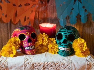 Composition of traditional altar for Mexican day of the dead with skull, candles , offering and flowers.