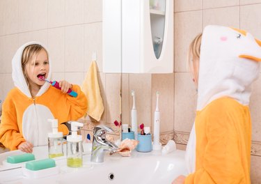 Child brushing teeth in a bathroom
