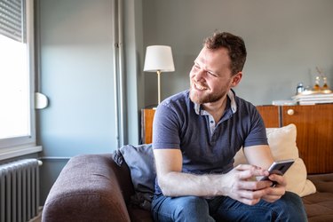 Young man is using smartphone at home