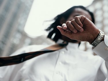 USA, NEW YORK CITY STREET BUSINESSMAN LOOKING AT WATCH