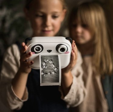 Child holding instant camera