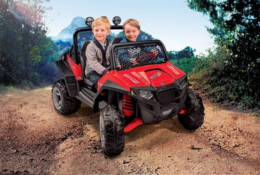 Two kids riding in red polaris