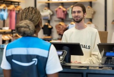 Amazon delivery person standing in front of retail worker