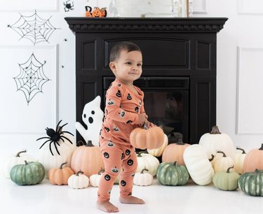 baby wearing pumpkin pajamas