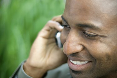 Close-up of a young man smiling talking on a mobile phone