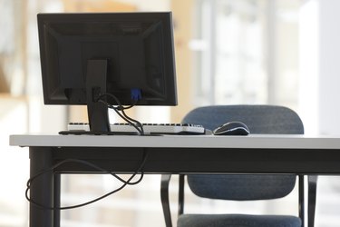 Computer equipment on desk with chair