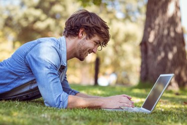 handsome hipster using laptop in park