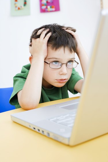 Frustrated boy using laptop computer