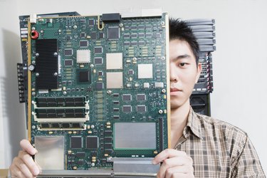 Computer technician holding motherboard