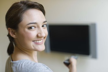 Woman using television remote control