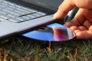 Human Hand Inserting Disc in to the Laptop