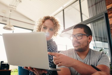 Graphic designers working in office using laptop