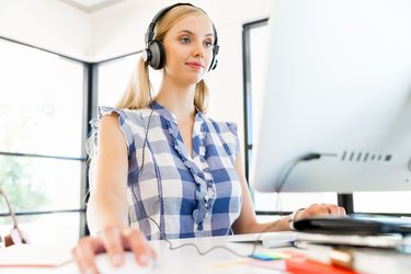 Young woman listening to the music while working on a