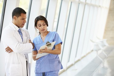 Medical Staff Having Discussion In Modern Hospital Corridor