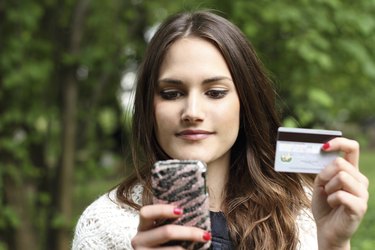 Beautiful girl with mobile phone and credit card