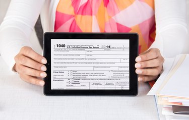 Business official showing income tax form 1040 on tablet computer