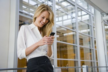 Smiling businesswoman texting