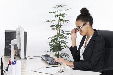 Young office worker looks at monitor