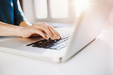 Female hand on a laptop keyboard