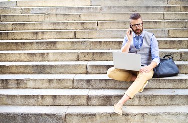 Hipster businessman with phone and laptop