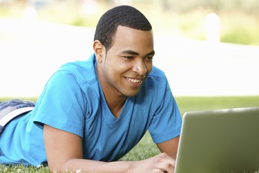 Young man using laptop outdoors