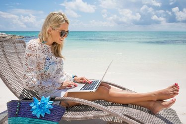 Businesswoman with computer on the beach