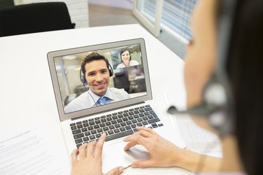 Деловая женщина в офисе на видеоконференции с гарнитурой, Skype