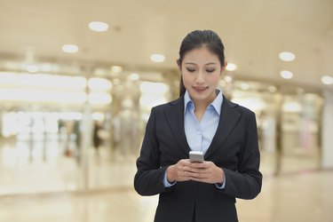 Young businesswoman indoor texting on her phone
