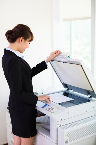 young businesswoman using  photocopy machine in office