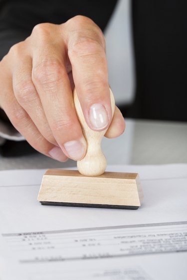 Business Man Hand Pressing Rubber Stamp On Document