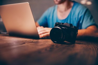 Man doing postproduction of his photos on laptop at night