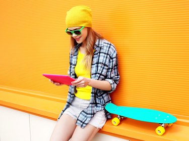 stylish cool girl using digital tablet pc in city