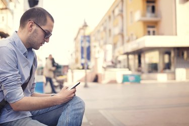 Young man using smartphone of street