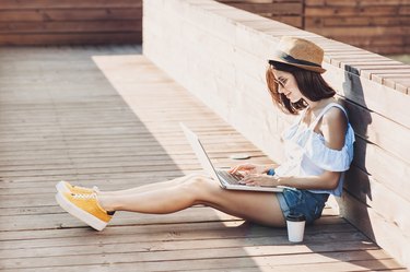 Young trendy girl using a laptop outdoors