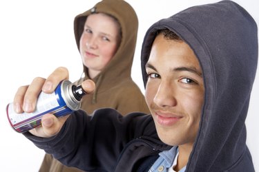 Teenage boys with can of spray paint