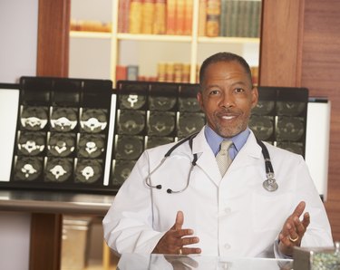 African American male doctor in front of MRIs