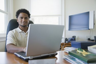 Portrait of a businessman using a laptop in an office