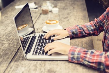 Schoolgirl with laptop and cappuccino