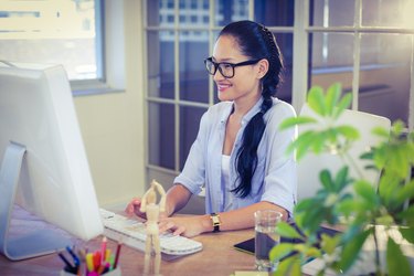 Happy young designer working at desk