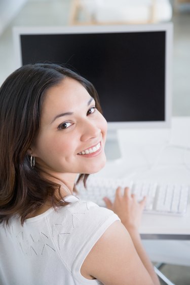 Woman at computer looking over her shoulder