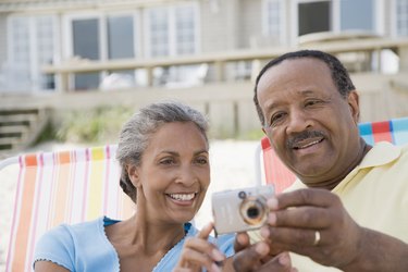 Senior man and a mature woman looking at a digital camera
