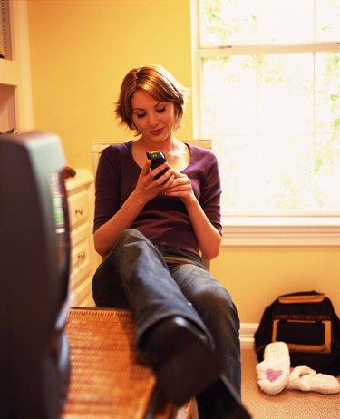 Woman using the phone in a bedroom